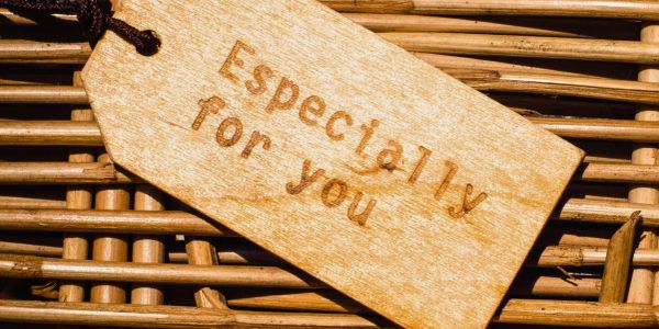 Wooden tag with the words "Especially for you" on a wicker surface.