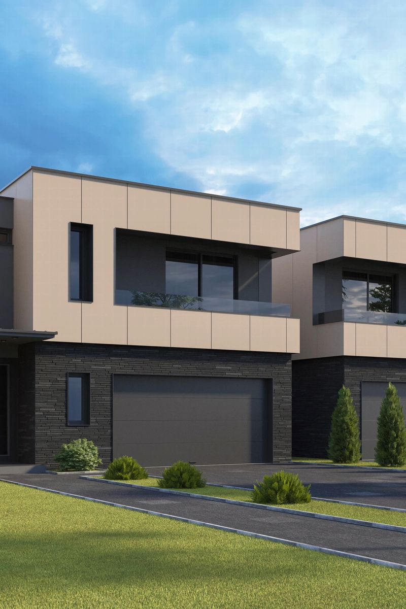 A modern multi-story residential building featuring a minimalist design with clean lines and a mix of materials including smooth white panels, dark gray accents, and textured brickwork. Large windows and glass blocks allow natural light to enter while maintaining privacy. Recessed lighting under architectural overhangs adds a refined touch, and the clear blue sky enhances the structure’s contemporary aesthetic. Ideal for use in real estate marketing, architectural portfolios, construction websites, urban planning presentations, and editorial content related to modern housing or city living.