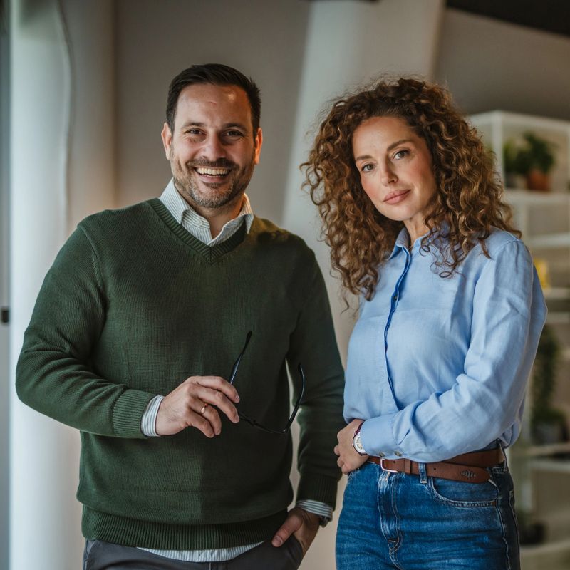 Diverse business professionals feeling confident and successful, standing side by side in a collaborative office environment after a productive meeting, representing partnership and teamwork
