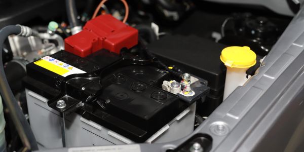 Car engine battery with red and black covers.