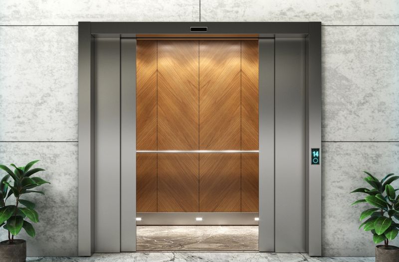 Contemporary elevator entrance set in a dark marble wall, dramatically highlighted by neon blue light strips for a high-tech look 3d illustration