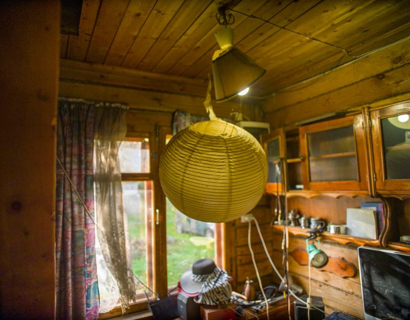 a chaos in the cluttered room with wooden walls and ceiling