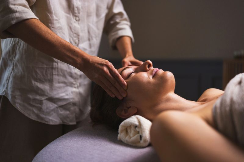 A calm therapist gently supports a client's head during a soothing head massage. The peaceful spa setting promotes relaxation, comfort, and renewal as hands ease tension and stress.
