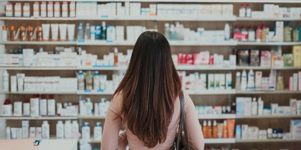 Woman browsing skincare products on store shelves.