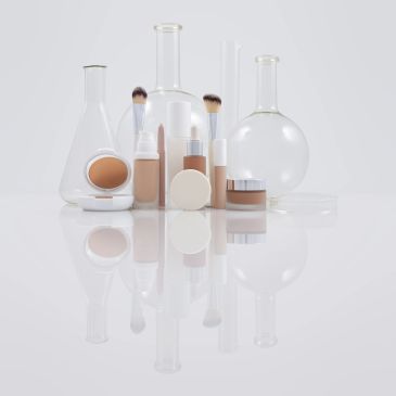 Makeup products displayed with laboratory glassware.
