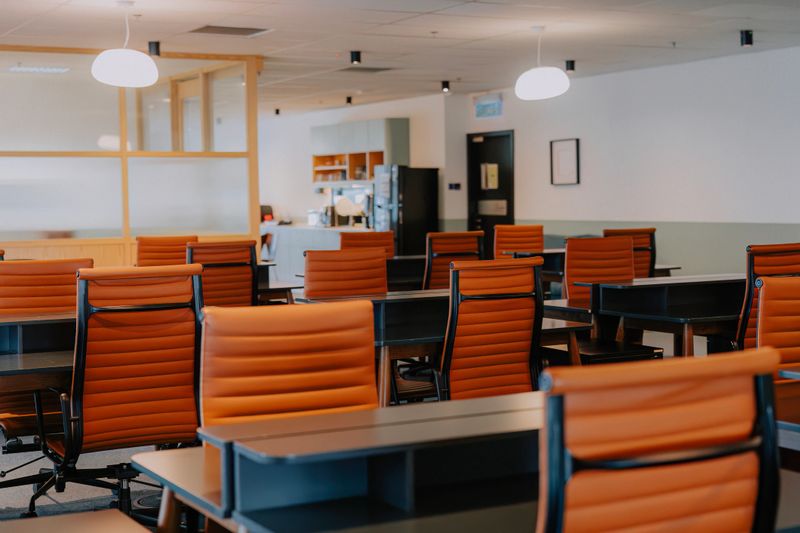 Contemporary coworking office interior featuring leather chairs, clean desks, and an organized workspace ideal for business and productivity themes. Kuala Lumpur.