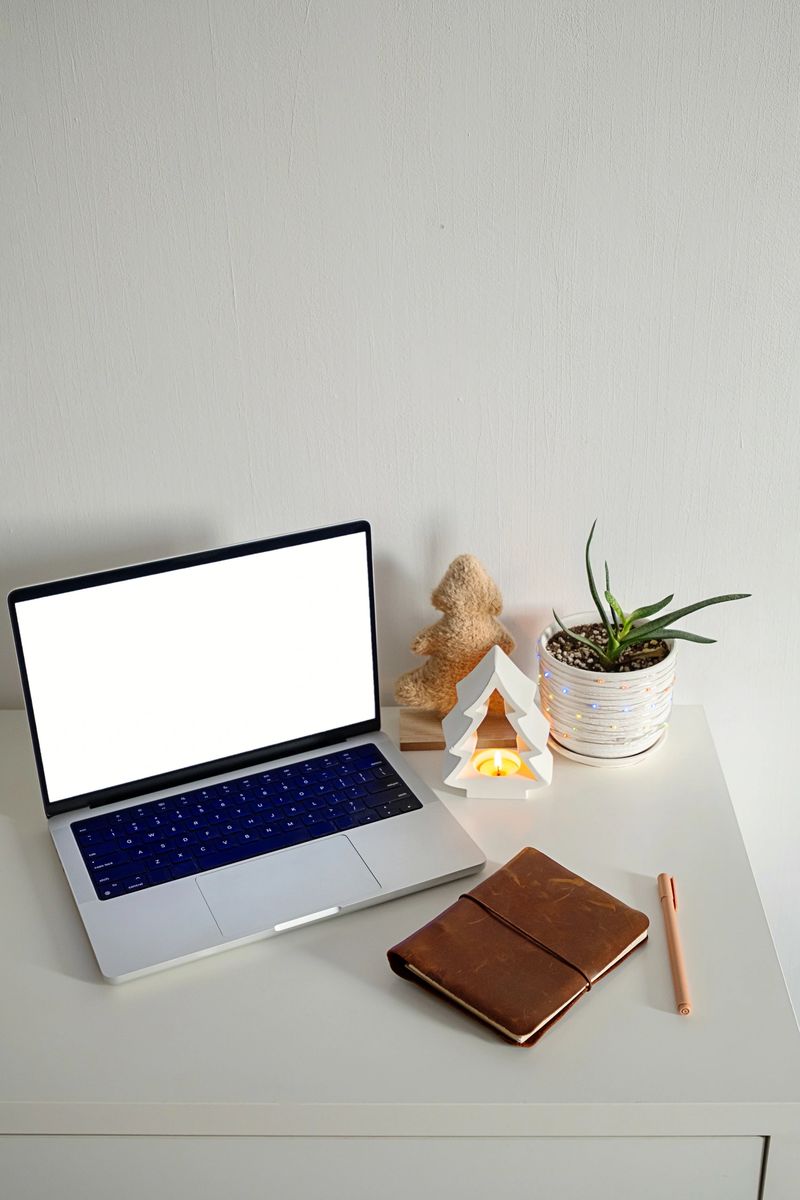 Laptop with blank screen on desk with festive Christmas decor. Winter holiday and creative workspace concept for designers.