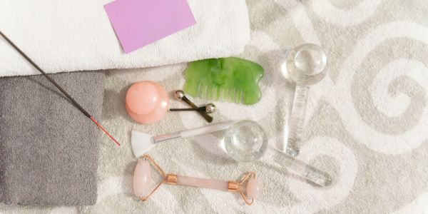 Facial massage and skincare tools arranged on towels.