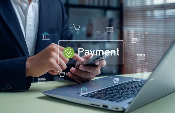 Person making a secure online payment using smartphone and laptop.