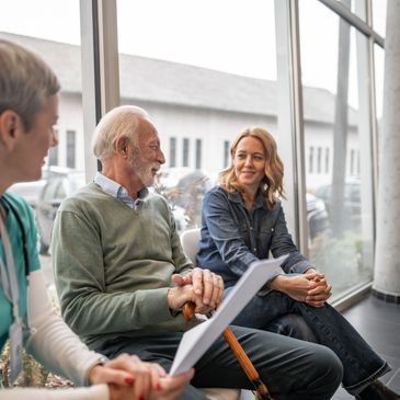 Healthcare professional meeting with a senior patient and family member.
