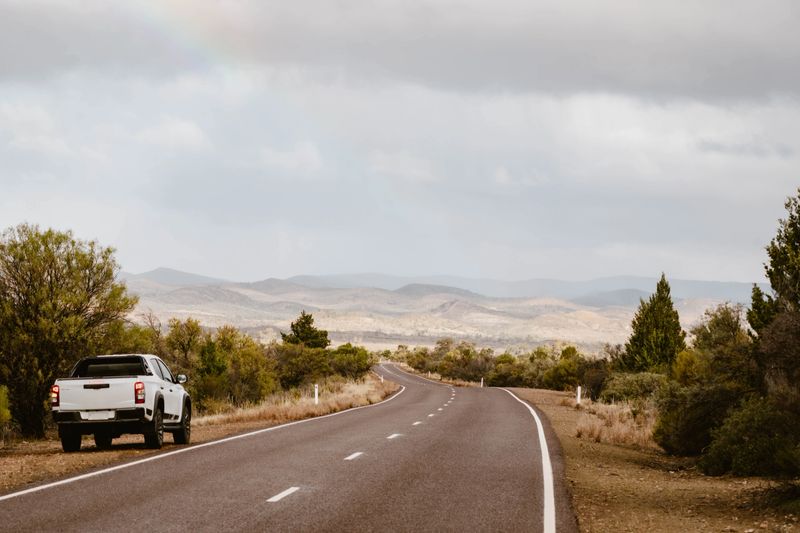 Off-road vehicle next to empty road in Australian outback in Flinders Ranges, South Australia, Australia