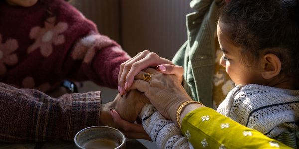 Generations connecting through holding hands warmly.