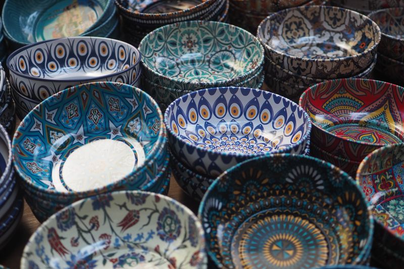 Handcrafted bowls of various patterns and colors fill the market stall.