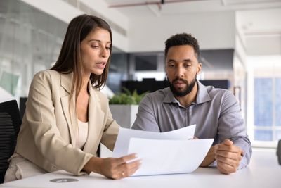 Business owner reviewing an unpaid invoice with a debt recovery adviser