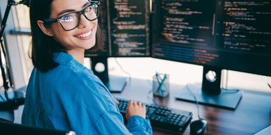 Mujer sonriente usando computadora y gafas.