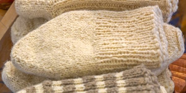 Close-up of a beige knitted mitten.