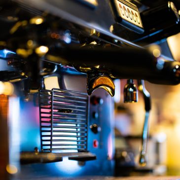 Close-up of an espresso machine with warm lighting.