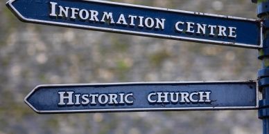 Street signs pointing to Information Centre and Historic Church.