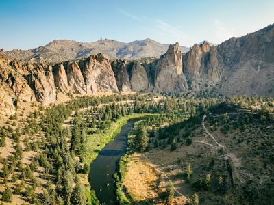 A winding river through a forested canyon with rocky cliffs.