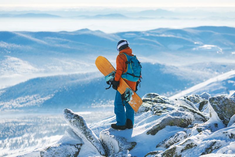 Mid adult man snowboarding at ski resort, spending his holiday at mountain