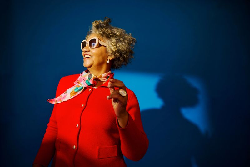 Mature adult woman in sunglasses laughing, embodying a vibrant, cool attitude