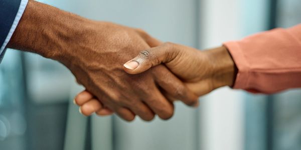 Close-up of two people shaking hands in a professional setting.