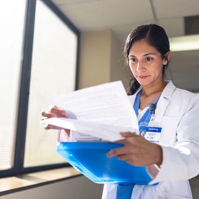 Physician reviewing patient records in a bright, modern medical office.