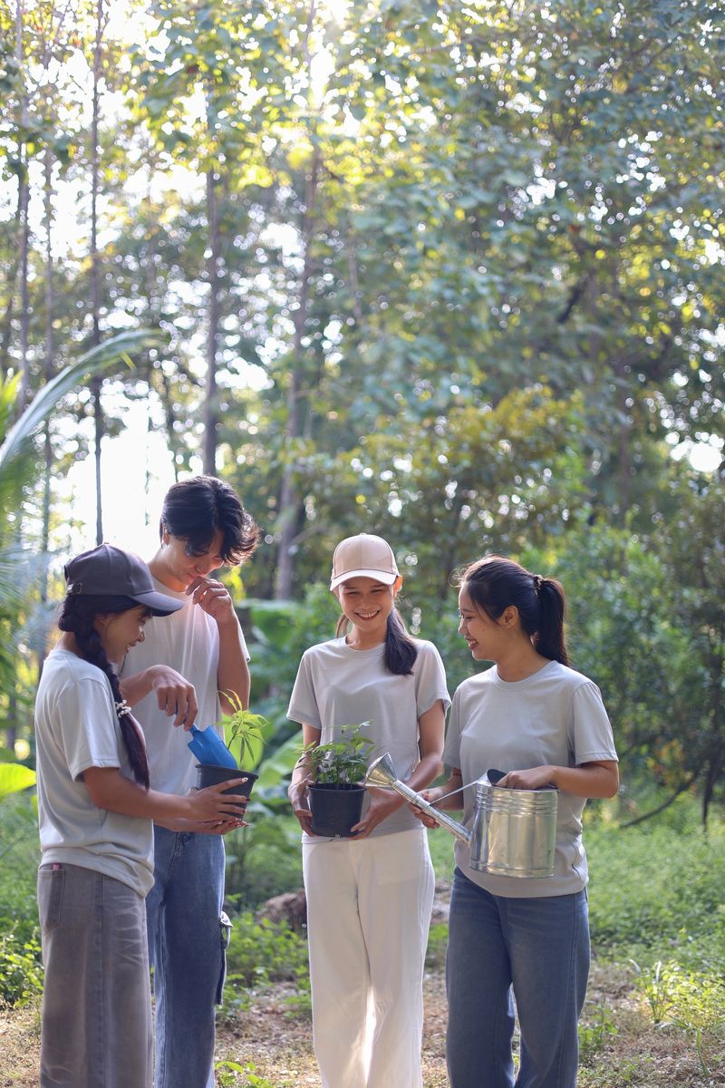 Young adults volunteer planting trees in the park for environmental conservation and sustainable future. Community service, reforestation, nature care and teamwork concept.
