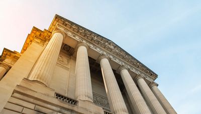 View of a classical building with pillars against the sky.