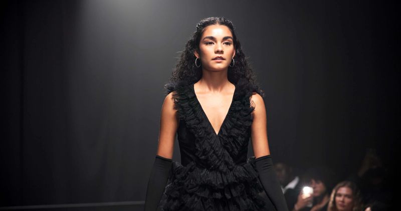 Woman, model and runway with luxury for fashion show, garment collection or designer brand. Space, crowd or paparazzi with clothing line or outfit for publicity or new aesthetic trend on catwalk