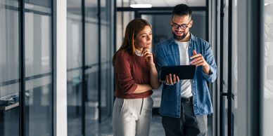 Two colleagues discussing with a tablet in an office.