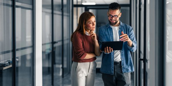 Dos jóvenes profesionales revisan una tablet en la oficina.