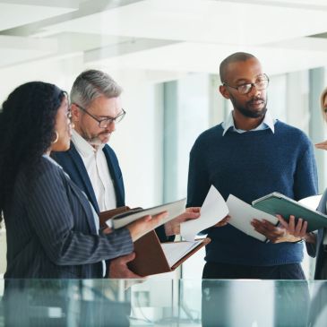 Group of professionals discussing documents in a modern office.