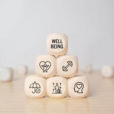 Wooden blocks depicting wellbeing and health symbols.