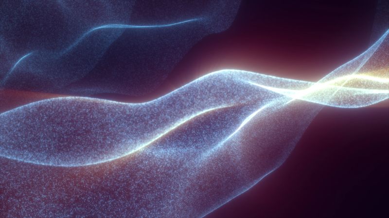 Soft glowing digital fabric made of countless tiny particles forming smooth luminous waves in warm tones.
