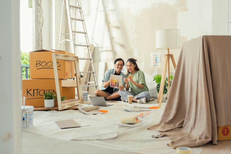 happy young couple collaborates on interior decor, choosing paint colors from a palette for their new home renovation, creating a beautiful, cozy space with teamwork and love.