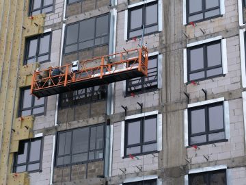 A construction platform suspended on the side of a building under construction.