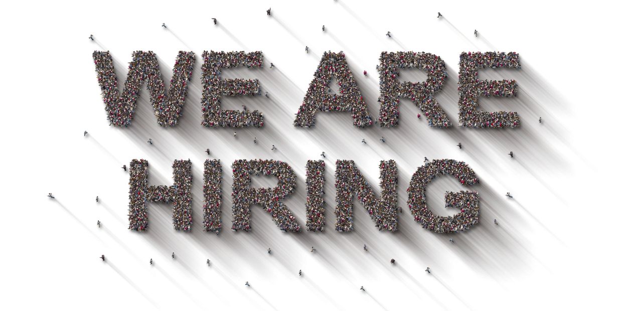 People forming the words 'WE ARE HIRING'.
