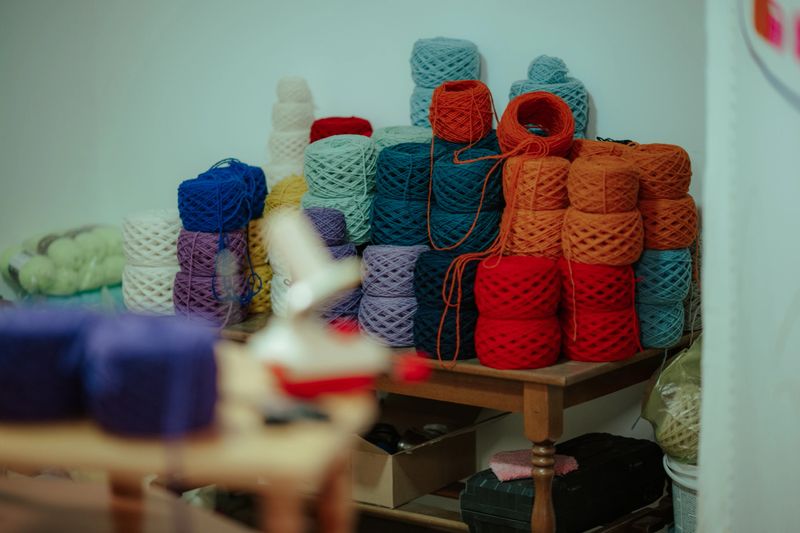 Rows of vibrant wool and acrylic yarn skeins creating a texture background for sewing, crocheting, and creative projects