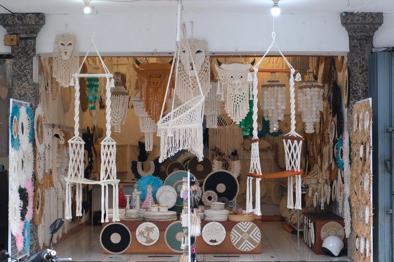 Bustling market stall filled with handcrafted Balinese items including dreamcatchers, wooden carvings, woven crafts, and home decor.