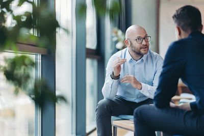 Two men engaged in a serious conversation in a modern office setting.