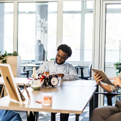 Man checking his watch at an office table.