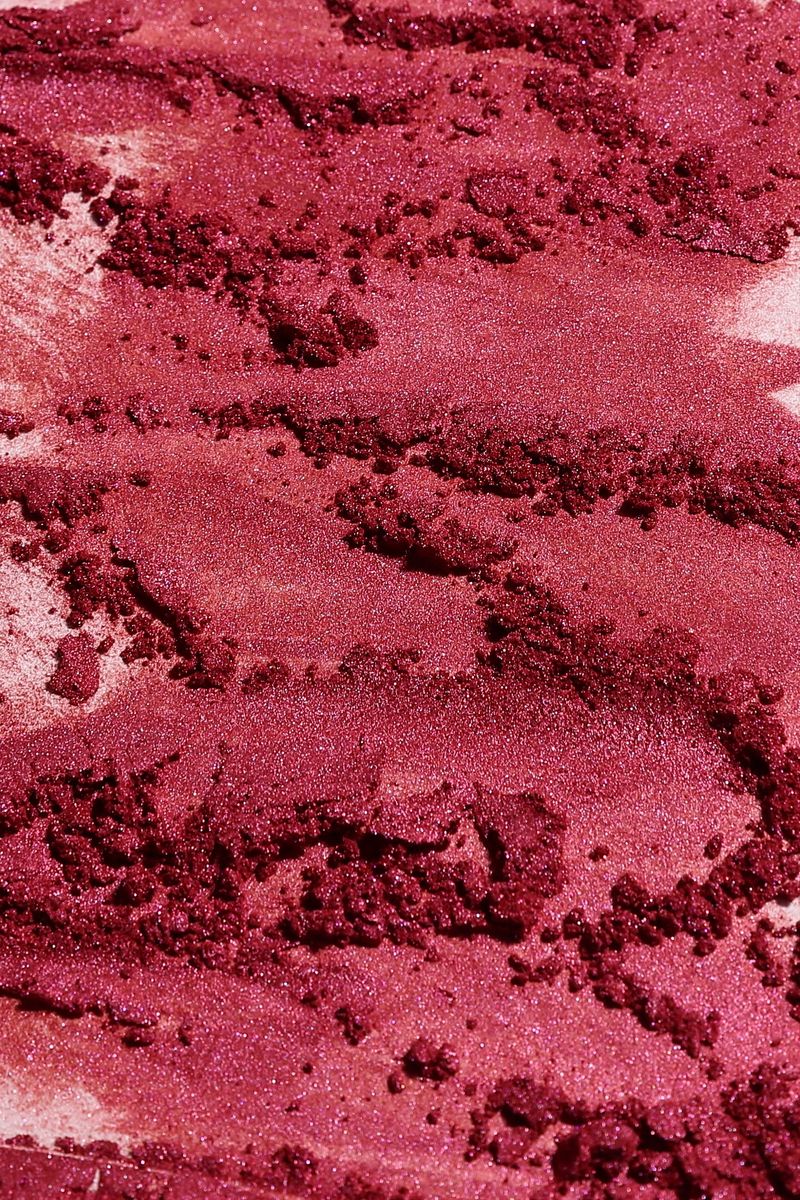 Red shimmer powder, crushed cosmetic smudge background