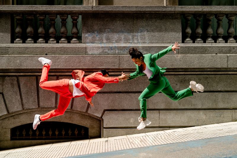 dressed in green and orange suits performing acrobatic jumps