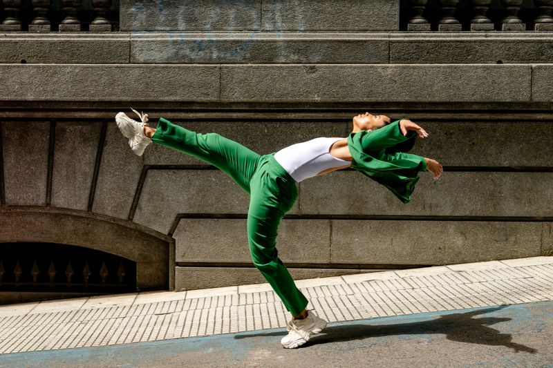 Woman in green suit jumps in the city
