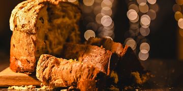 Loaf of bread sliced on table with blurred bokeh lights.