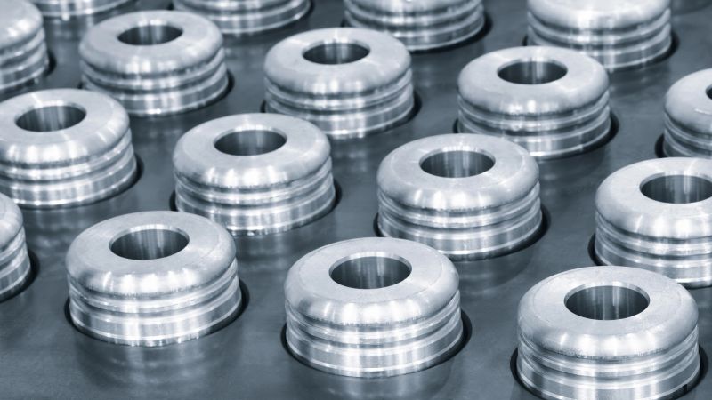 Quality testing of metal parts, round metal parts lying in rows on a quality control test table, industrial concept background.