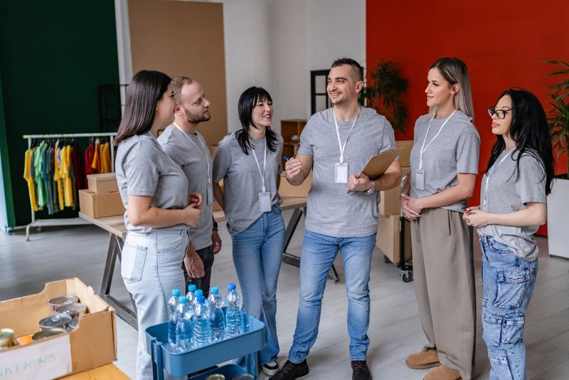 A group of community volunteers engages in discussion while organizing donation supplies at a food bank. They share smiles and work together to support local charity.