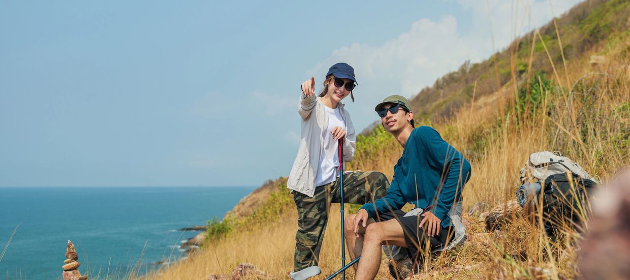Group of people posing on a cliff with a scenic mountain view.