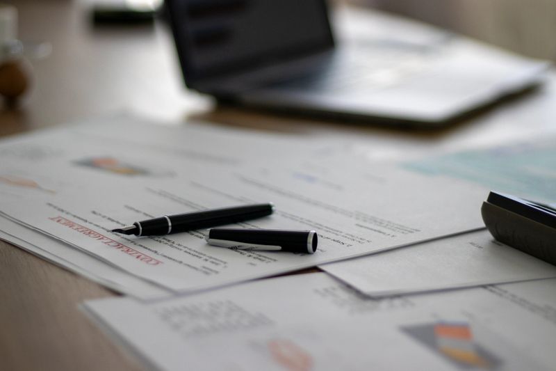 Close-up view of a contract document with a pen on a desk, legal and financial paperwork in a professional workspace, global business agreement and administrative responsibility concept for compliance and documentation